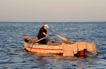 تسحب سارة السويسي قاربها الصغير على شاطئ جزيرة قرقنة في جنوب تونس